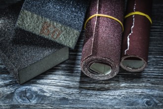 Rolled abrasive paper blocks on vintage wooden board