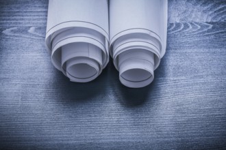 White rolled up blueprints on blue painted board
