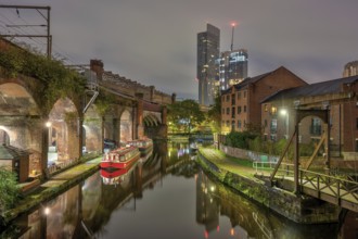 Castlefield in Manchester, Great Britain, at night, with a modern skyscraper in the background