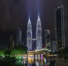 A picture of the Petronas Twin Towers, the KLCC Park water and light fountain show and the Suria