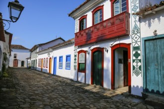 Typical cobblestone street with decorative and colorful colonial buildings in late afternoon light
