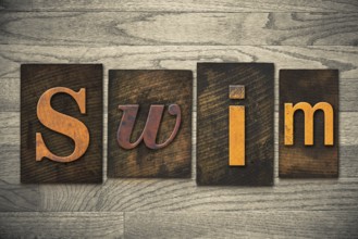 The word SWIM written in wooden letterpress type