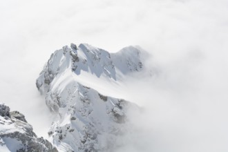 Sunny mountain of the Dachstein mountain range stands out in the carpet of fog