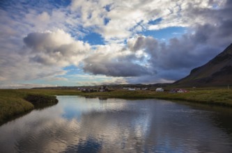 Quiet summer evening on the coast of Iceland. Small pond in the fishing settlement of Arnastapi