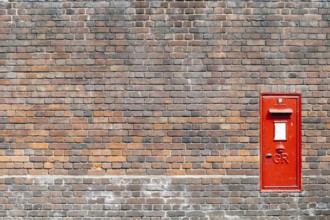 Red mail box in a brick wall