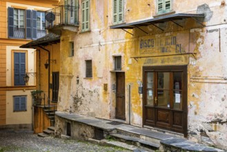 Orta San Giulio, Italy, 13 March, 2023: colorful shabby buildings in the old town center of Orta