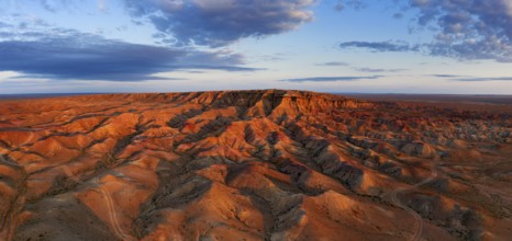 Aerial panorama of textural colorful striped canyons Tsagaan suvarga, White stupa at sunrise.