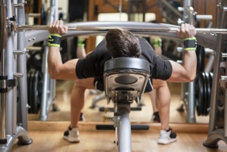 Sport, bodybuilding, lifestyle and people concept, young man with barbell flexing muscles and