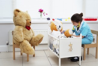 Caucasian girl nursing her teddy bear themes of daydreaming imagination ambition