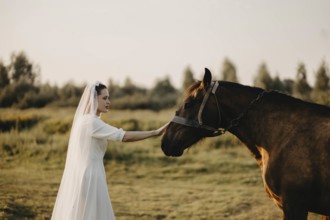A bride gently touching a horse in a serene natural landscape, symbolizing harmony