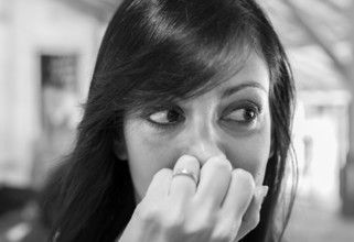 Close up portrait of young woman looking for something. Defocused blurry background