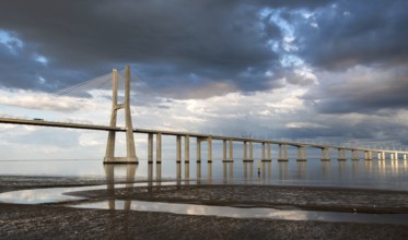 Vasco da Gama Bridge at sunset with dramatic cloudy sky in Lisbon