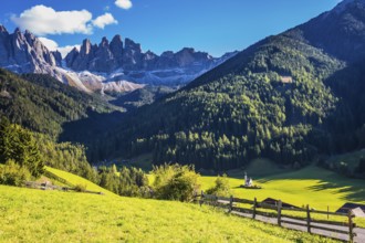 Picturesque little church of Santa Maddalena in valley Val di Funes. Sunny day in Dolomites, Tirol.