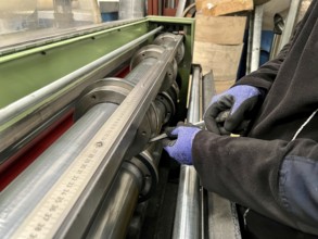 Technician worker placing the blades of a machine to cut steel coils. Industrial environment and