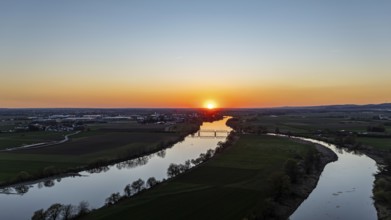River (Danube) in the foreground with setting sun on the horizon, surrounded by fields, wide and