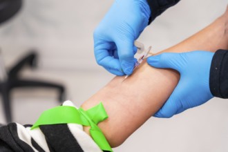 Close-up of nurse using needle to extract blood sample from a woman