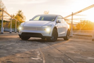 Perspective on a white car at sunset in a city car park, Tesla new Model Y Juniper, Nagold, Germany