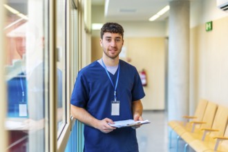 Portrait of a confident male nurse reviewing patient files, showcasing professionalism and