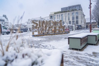 Snow-covered lettering of Sindelfingen, surrounded by an urban landscape, Sindelfingen, Germany