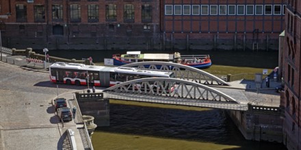 An articulated bus on the small Pickhuben bridge and a ship on Brooksfleet seen from above,