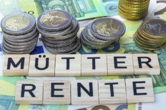 Mothers' pension Symbolic image: letter blocks on euro banknotes show the word MÜTTERRENTE