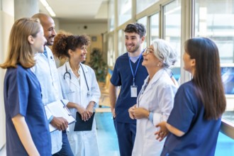 Doctors and nurses sharing a friendly moment, talking and smiling together in a hospital corridor