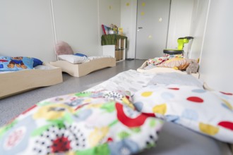 Cosy children's bedroom with beds, colourful cushions and toys, transitional daycare centre in