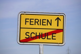 (Photomontage) Symbolic image summer holidays: Town exit sign with text HOLIDAYS and SCHOOL