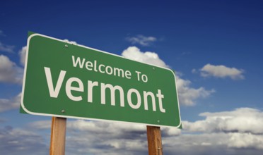 Welcome to vermont green road sign over blue sky with some clouds