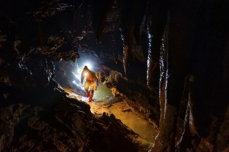 Speleologists climbing through a passage, Advent Cave, Schneizlreuth, Berchtesgadener Land, Upper