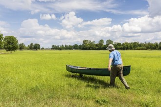 Man transferring a canoe, Große Röder near Wildenhain, Großenhain, Saxony, Germany