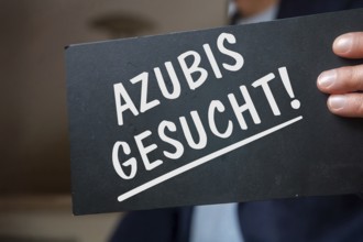 Trainees wanted: A man holds a sign with the words AZUBIS gesucht (symbolic image)