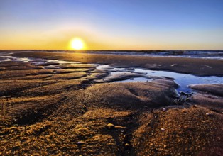 Atmospheric sunrise over the mudflats with the North Sea, Wyk auf Föhr, North Frisia,