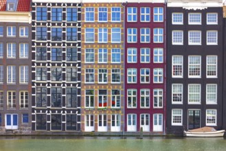Holland, Amsterdam Damrak canal houses with scenic bridges in historic center, UNESCO Heritage site