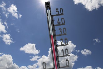 (Photomontage) Symbolic image of heat: thermometer in front of a summer sky