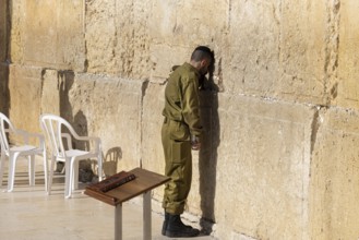 Jerusalem, Israel, 15 April, 2022: Israeli soldier praying in front of Sacred Western Wall in