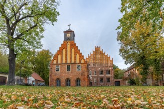 Autumn atmosphere with leaves in the meadow in front of Zinna Monastery with its brick