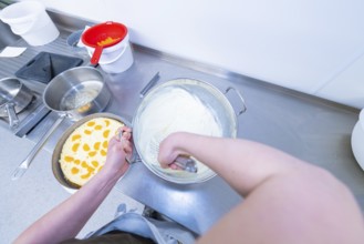 Person preparing cream in a bowl next to a cake base, cake baking, Haselstaller Hof Cafe Kuh,