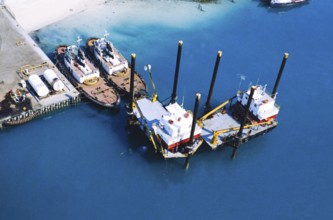 Oil industry in the Ras Tanura area, Saudi Arabia, tugs moored to platforms, 1979
