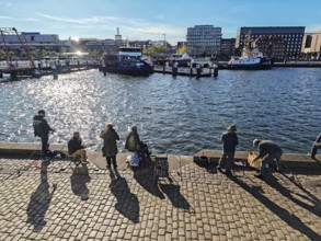 Kiel harbour at the end of the Kiel Fjord, view from the eastern shore with anglers to the western
