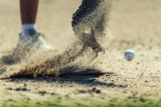 A golf ball is hit out of the bunker