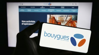 Stuttgart, Germany, 11-22-2023: Person holding smartphone with logo of French telecommunications