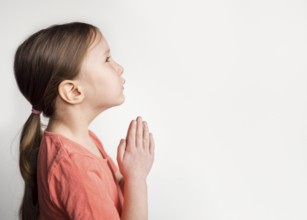 Beautiful little girl praying with copy space
