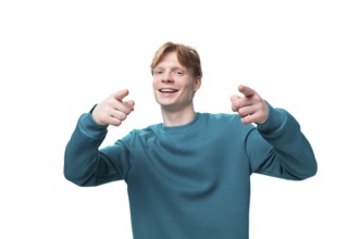 Young positive man with red hair shows his hands on space for news