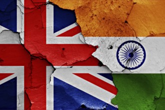 Flags of UK and India painted on cracked wall