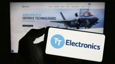 Stuttgart, Germany, 04-20-2023: Person holding cellphone with logo of British company TT