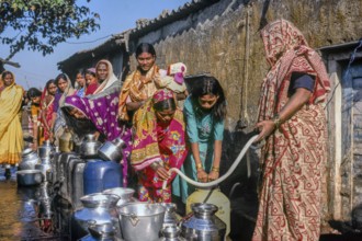 Women standing in queue to collect water in slum, Mumbai, Maharashtra, India, Asia