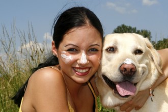 Woman and Labrador retriever with sun cream, sunscreen