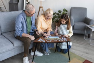 Grandparents girl doing puzzle full shot