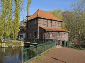 Brick mill with bridge, red roof and surrounding river, metelen, westphalia, germany